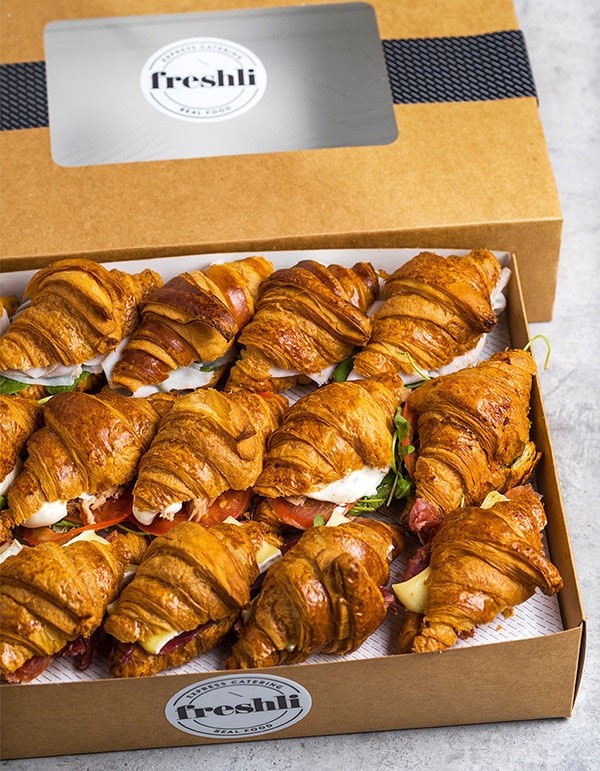 Box de 15 unidades de mini croissants rellenos de jamón ibérico, queso cheddar, lechuga iceberg y tomate en rodajas.